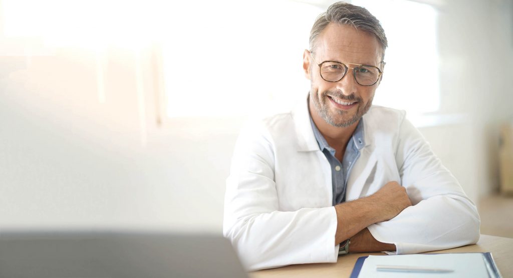 Portrait of mature, doctor sitting in medical office