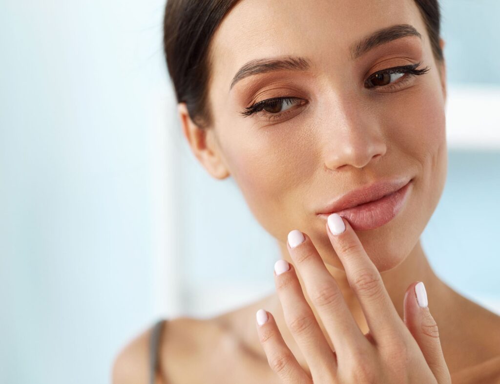 A woman touching her lips while looking to the result of Renveau liquid PDO by Les Encres Threads.